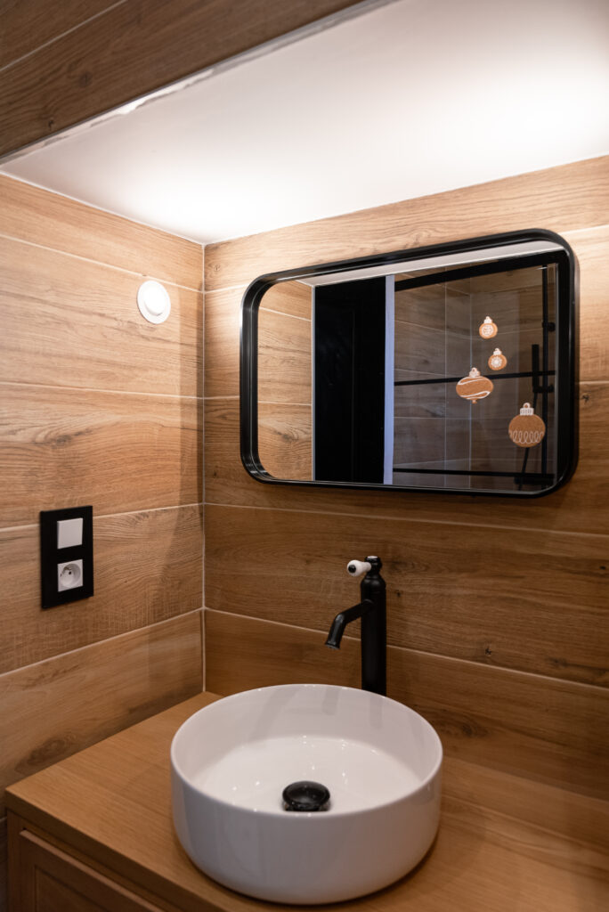 Photo d'une vasque de salle de bain moderne avec robinet noir et miroir noir